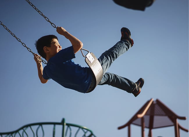 A boy on a playground swing